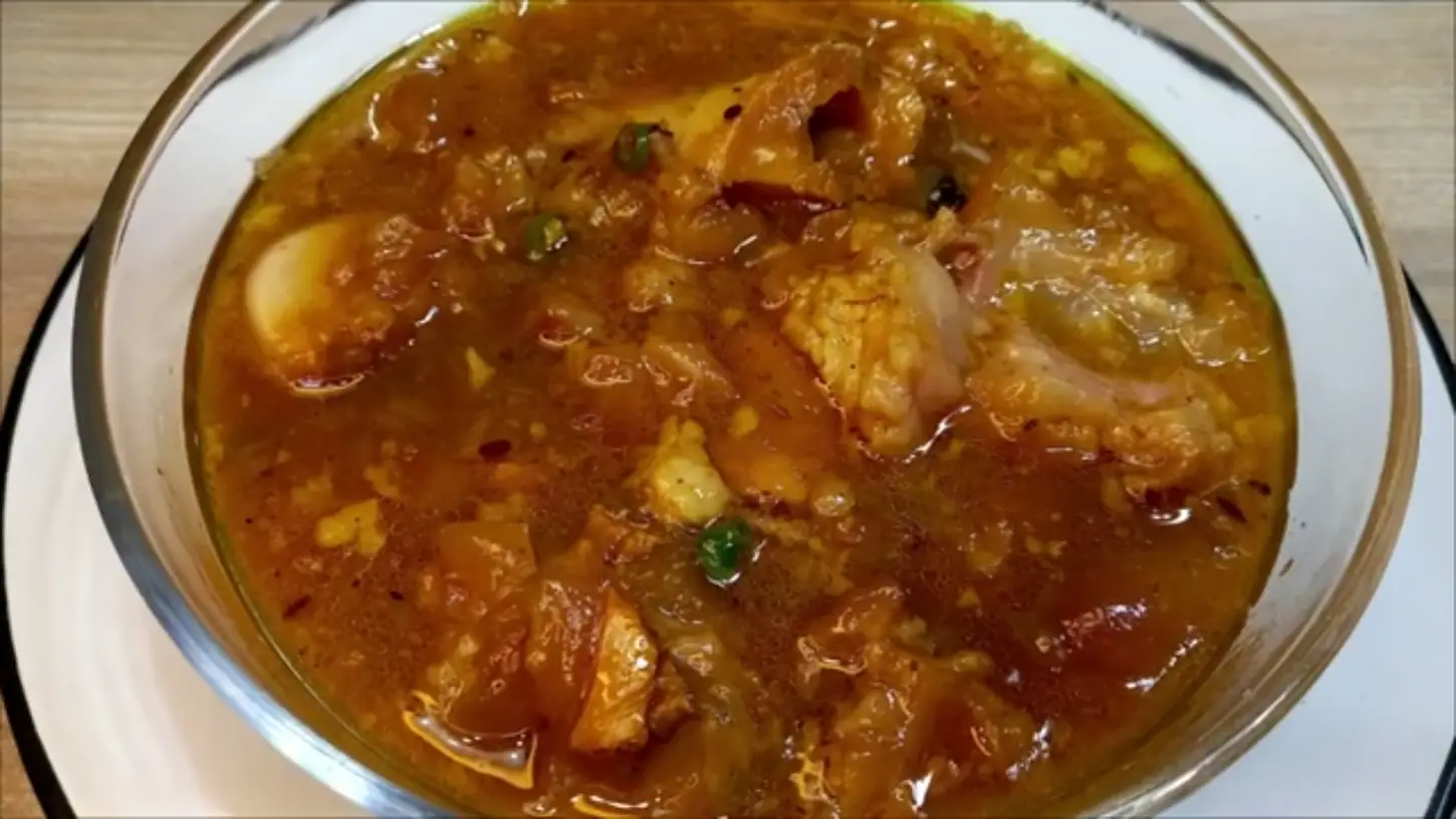 serving the hot beef paya curry in a glass bowl
