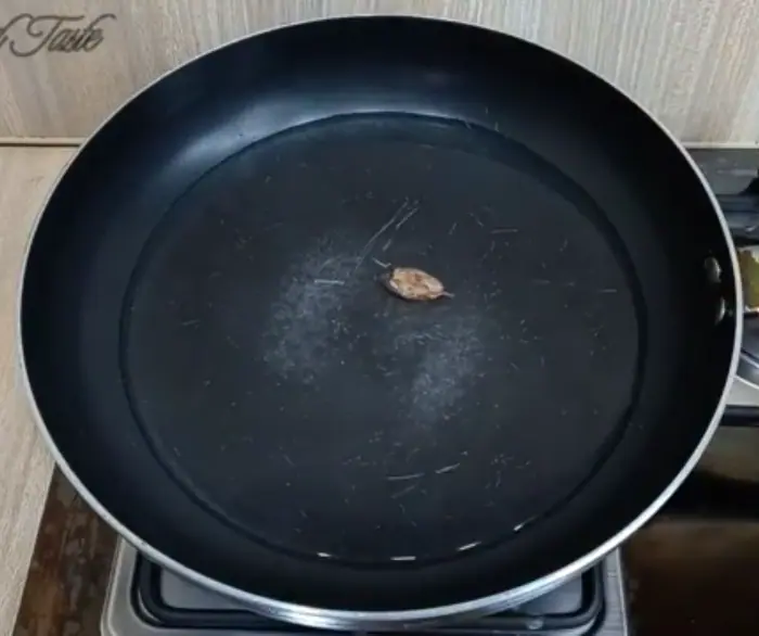 water, salt, and a large cardamom in a frying pan