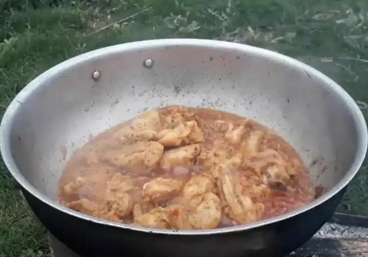cooking the chicken in a karahi on a medium flame