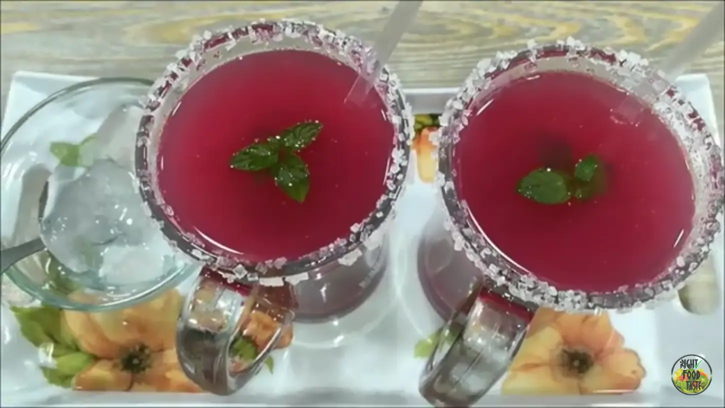 glassed filled with falsa juice, ice cubes, and garnished with a sprig of fresh mint leaves