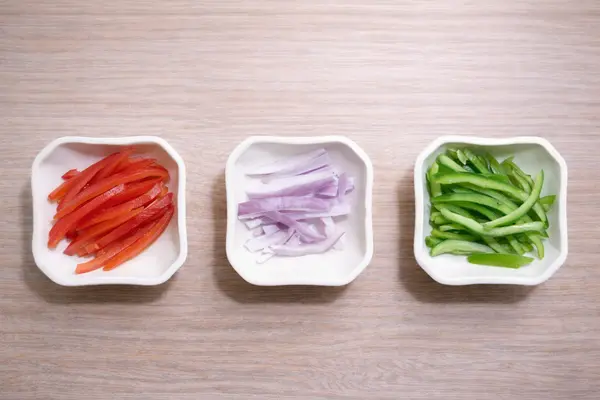 Julienned tomato, onion, and capsicum prepared for pizza toppings