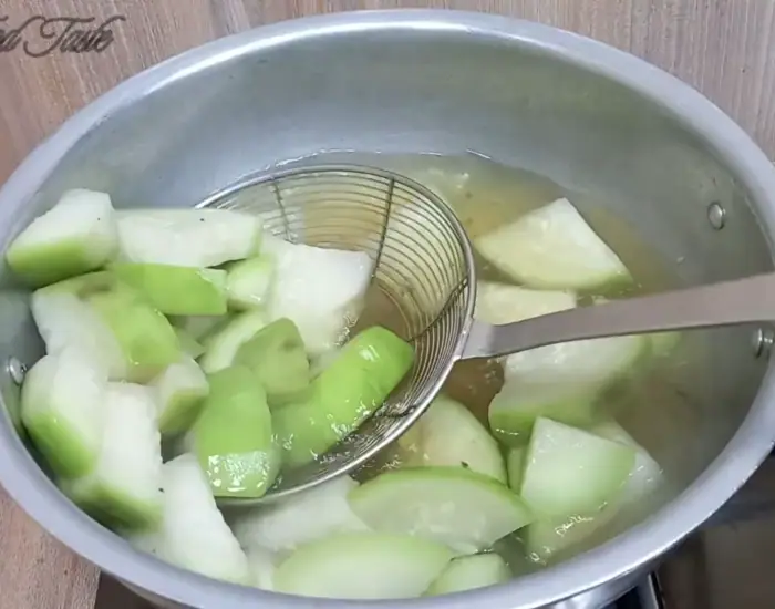 taking out the lauki pieces with a sieve