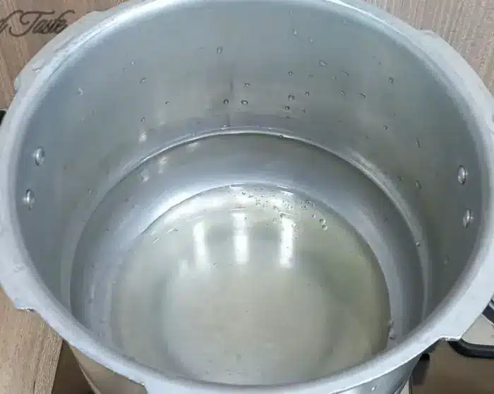 heating up cooking oil in a pressure cooker on medium heat
