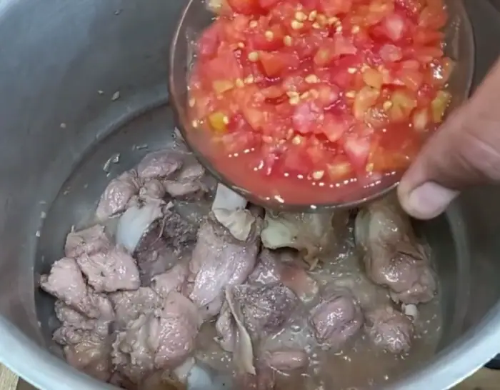 sautéing beef over a medium flame and then adding chopped tomatoes