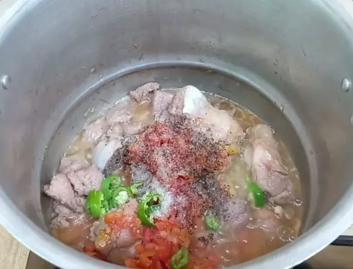adding coarsely ground balck pepper, sliced fresh green chilies, and salt